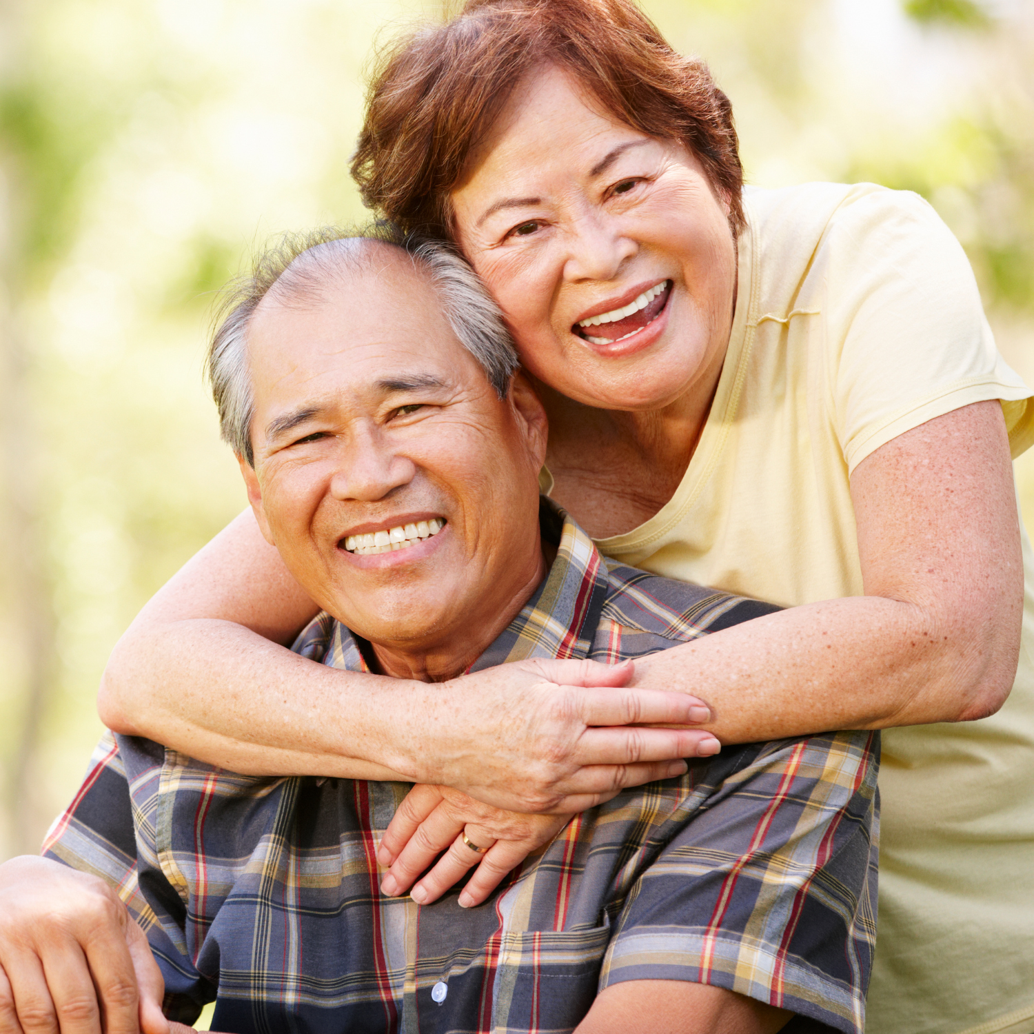 "Smiling senior couple embracing outdoors, representing family connection central to aging in place.